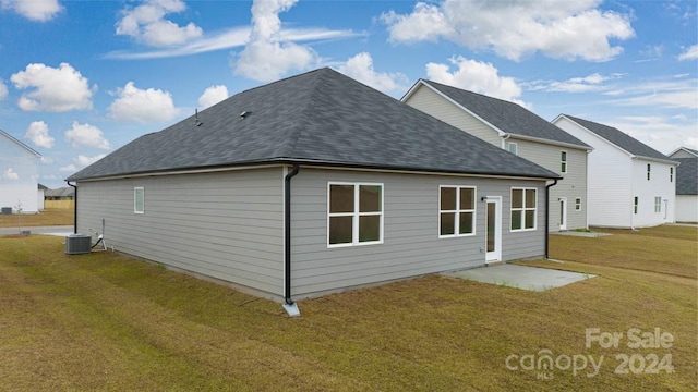 view of side of property with a patio area, central air condition unit, and a lawn