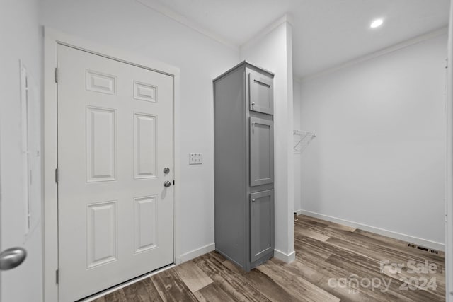 clothes washing area with crown molding and dark hardwood / wood-style flooring