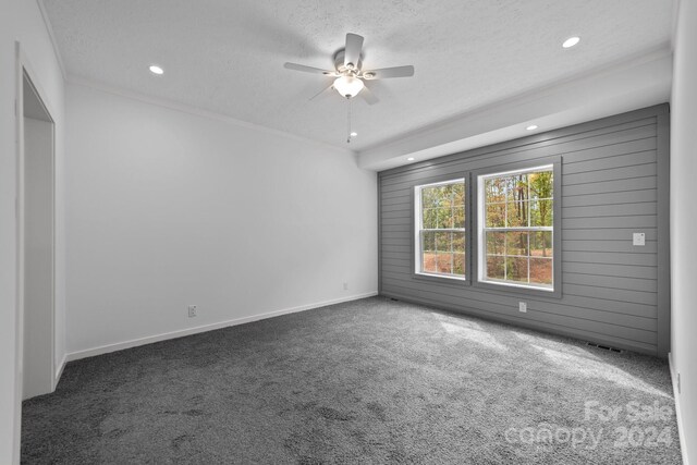 carpeted spare room featuring a textured ceiling and ceiling fan