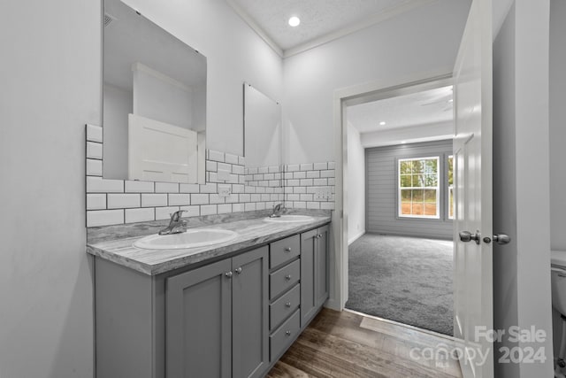 bathroom featuring vanity, toilet, a textured ceiling, backsplash, and hardwood / wood-style floors