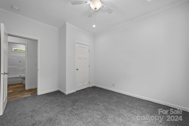 unfurnished bedroom featuring dark colored carpet, a closet, a textured ceiling, ornamental molding, and ceiling fan