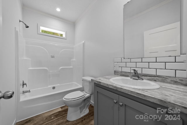 full bathroom with hardwood / wood-style flooring, tub / shower combination, ornamental molding, vanity, and toilet