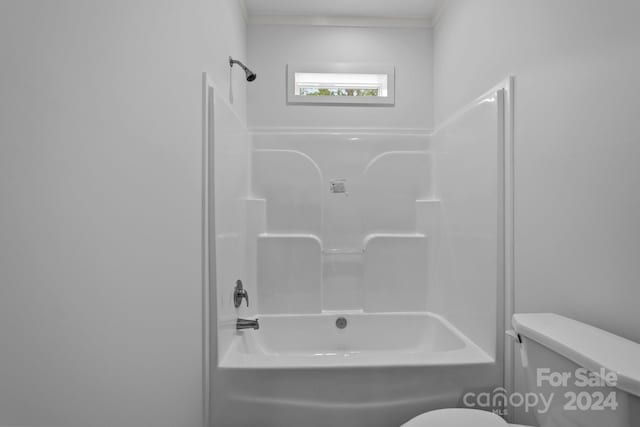 bathroom featuring washtub / shower combination, crown molding, and toilet