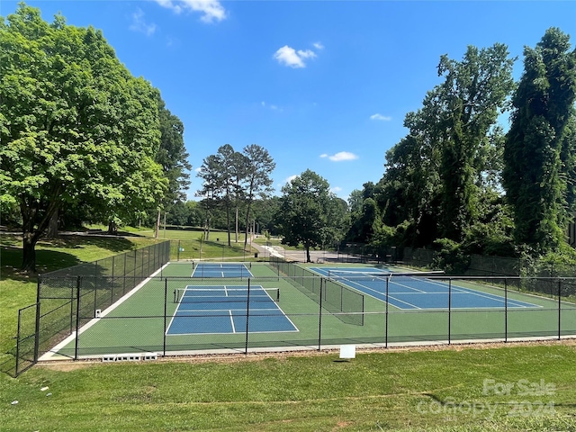 view of tennis court featuring a lawn