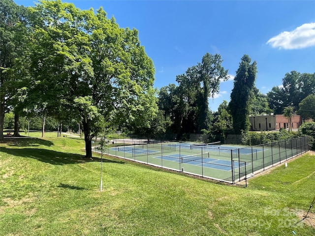 view of tennis court with a yard