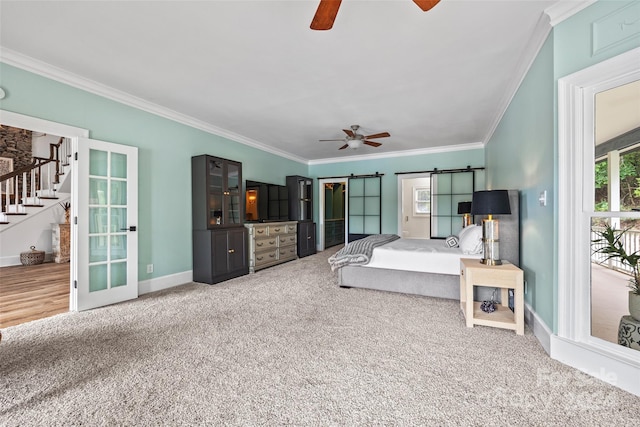 carpeted bedroom with ornamental molding, a barn door, and ceiling fan