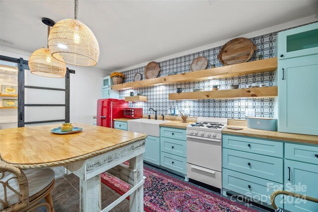 kitchen with butcher block countertops, blue cabinets, backsplash, white gas stove, and sink