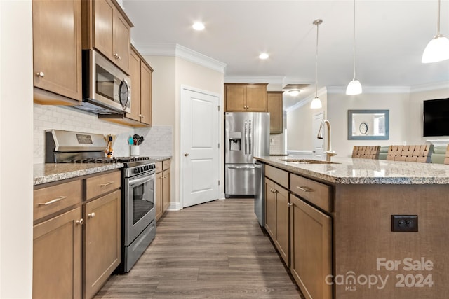 kitchen featuring dark hardwood / wood-style floors, backsplash, hanging light fixtures, appliances with stainless steel finishes, and sink