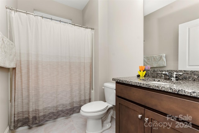 bathroom with vanity with extensive cabinet space, tile flooring, and toilet