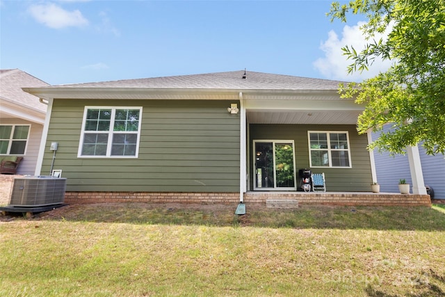 back of house with central AC and a yard