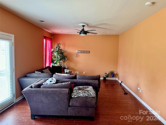 living room featuring ceiling fan and dark hardwood / wood-style flooring