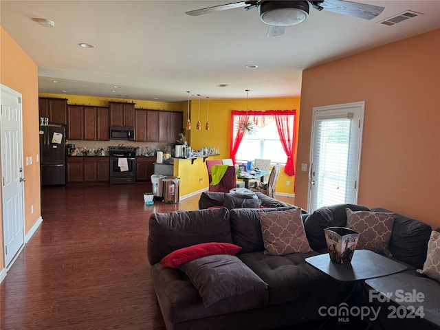 living room featuring ceiling fan and dark wood-type flooring