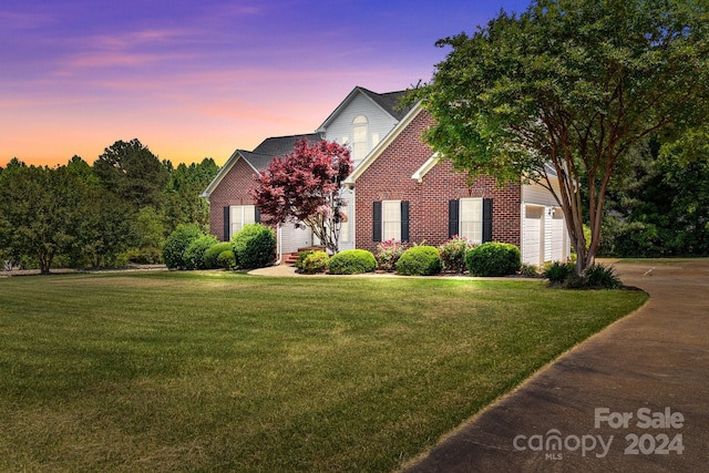 view of front of house featuring a garage and a yard