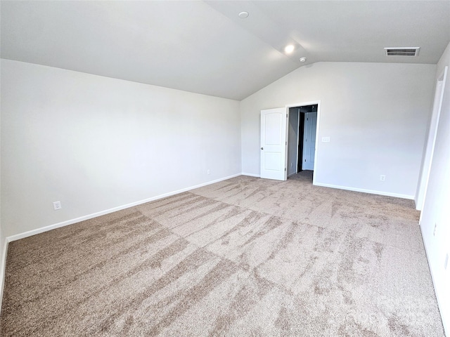 interior space with light carpet and vaulted ceiling