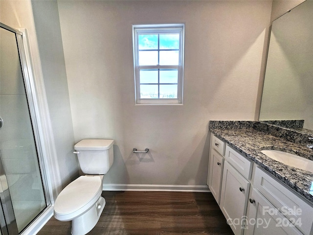 bathroom with hardwood / wood-style flooring, vanity, walk in shower, and toilet