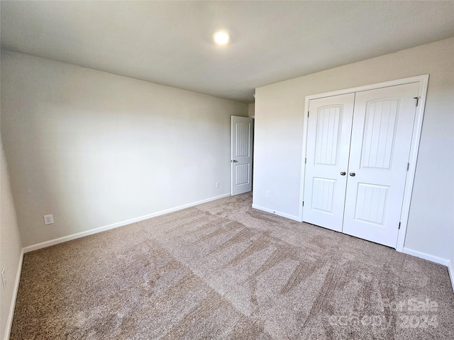 unfurnished bedroom featuring carpet flooring and a closet