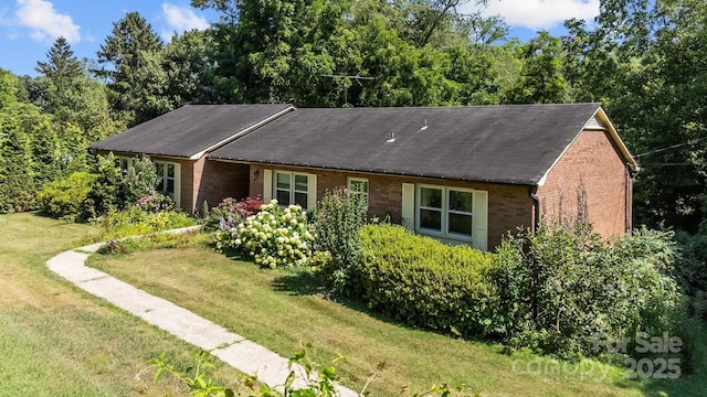 ranch-style house with a front yard and brick siding