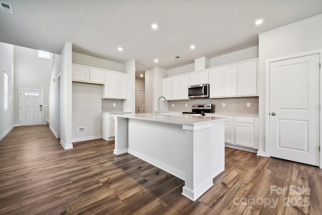 kitchen featuring white cabinetry, an island with sink, and stainless steel appliances