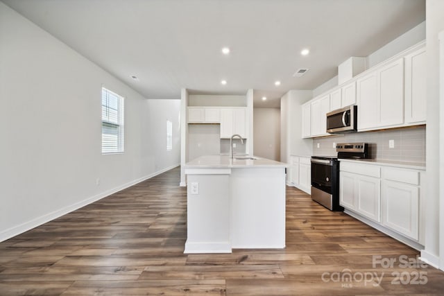 kitchen featuring stainless steel appliances, a kitchen island with sink, dark wood-type flooring, sink, and white cabinets