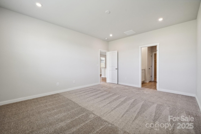 unfurnished bedroom with ensuite bathroom and light colored carpet