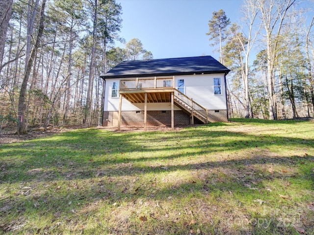 rear view of property featuring a lawn and a wooden deck