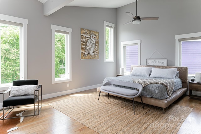 bedroom featuring ceiling fan, multiple windows, and hardwood / wood-style floors