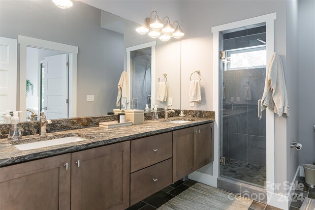 bathroom with tile floors, an enclosed shower, and double sink vanity