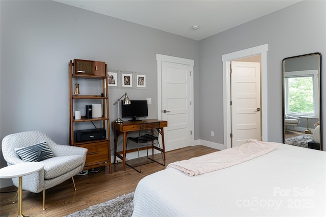 bedroom featuring wood finished floors and baseboards