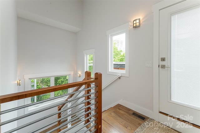 staircase featuring visible vents, baseboards, and wood finished floors