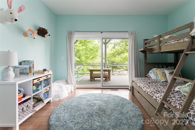 bedroom with access to exterior and wood finished floors