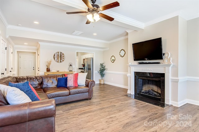 living room featuring a high end fireplace, hardwood / wood-style flooring, and ornamental molding