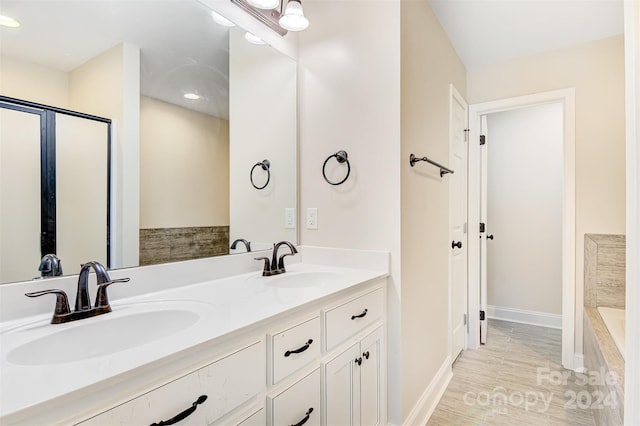 bathroom featuring tiled bath and vanity