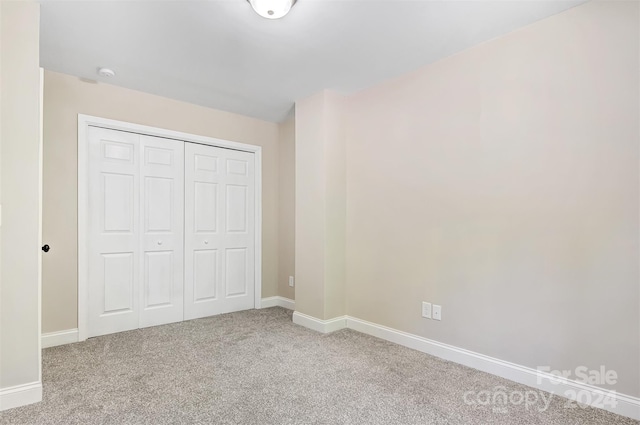 unfurnished bedroom with carpet flooring and a closet