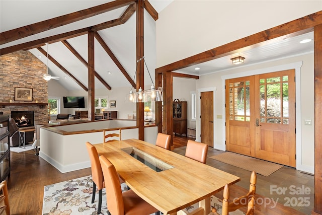 dining space featuring french doors, beam ceiling, high vaulted ceiling, dark hardwood / wood-style flooring, and a fireplace