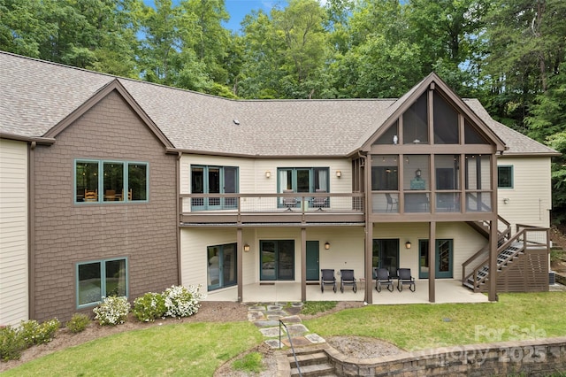 rear view of house with a sunroom, a yard, and a patio