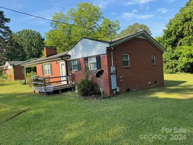 back of property with a deck and a yard