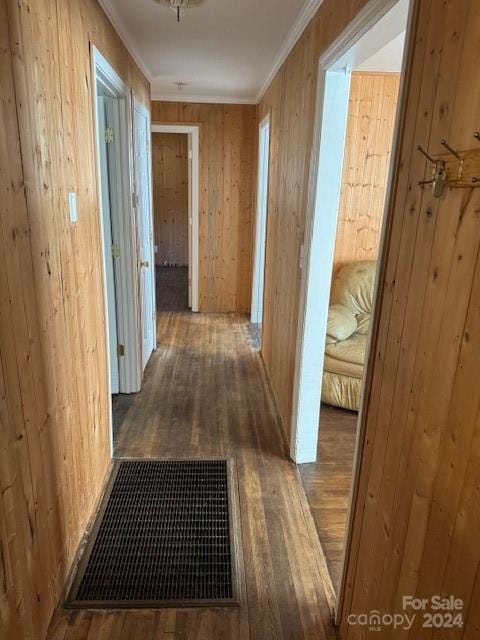 hall featuring crown molding, hardwood / wood-style flooring, and wooden walls