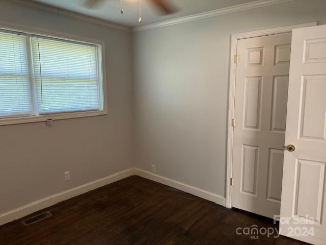 unfurnished room with crown molding, dark hardwood / wood-style floors, and ceiling fan