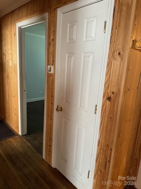 hall with wood-type flooring and wood walls