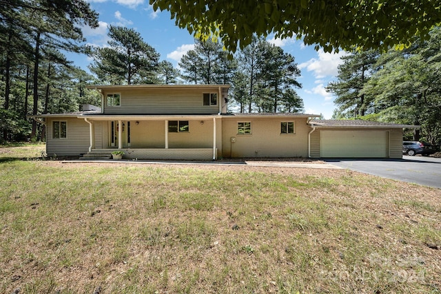 view of front facade featuring covered porch, a front lawn, and a garage