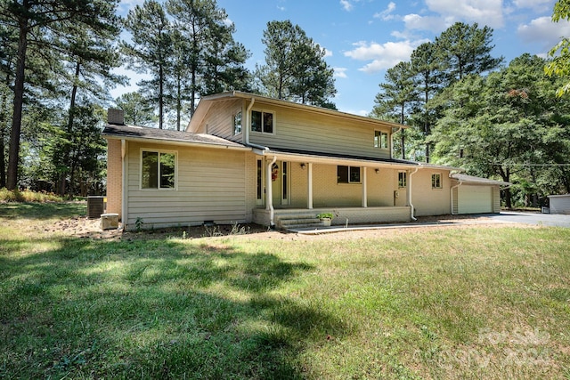 view of front facade featuring a front yard, a garage, a porch, and central AC