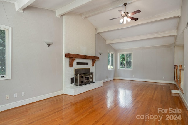 unfurnished living room featuring wood-type flooring, a brick fireplace, ceiling fan, and vaulted ceiling with beams