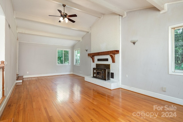 unfurnished living room with hardwood / wood-style floors, a fireplace, ceiling fan, and vaulted ceiling with beams