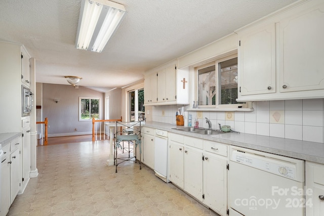 kitchen with white dishwasher, a textured ceiling, stainless steel microwave, white cabinets, and sink