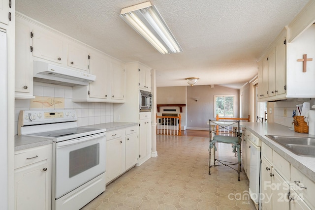 kitchen featuring sink, white cabinets, a textured ceiling, white appliances, and tasteful backsplash