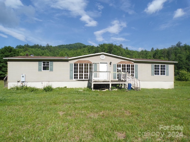 back of property with a yard and a deck