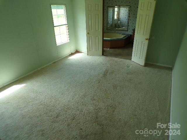 unfurnished bedroom featuring light carpet