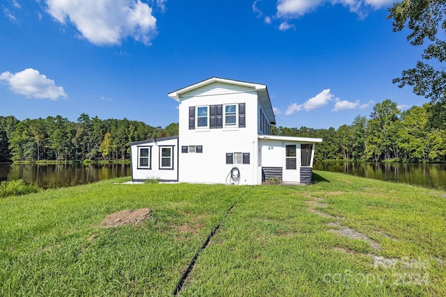 back of house featuring a yard and a water view