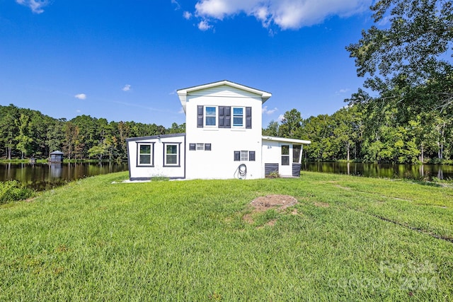 back of property featuring a lawn and a water view