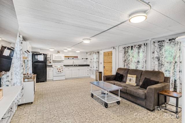 tiled living room with sink, a textured ceiling, and a wall mounted AC